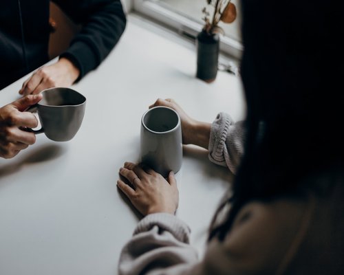 A close up of hands holding a warm mug