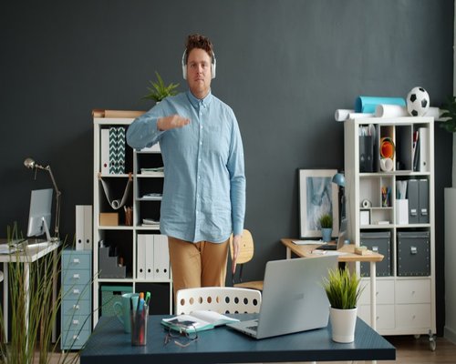 Person doing a gentle stretch standing by their desk