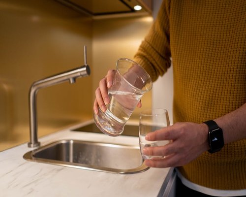 Pouring a glass of water in a kitchen